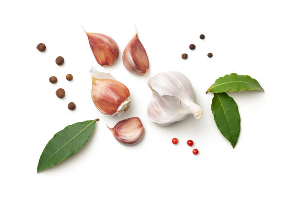 Garlic, bay leaves, allspice and pepper isolated on white background